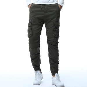 Dettaglio dei pantaloni cargo olive con coulisse in vita e ampie tasche laterali a patta