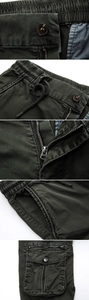 Detail of olive cargo pants showing elastic drawstring waist and metal zipper fly