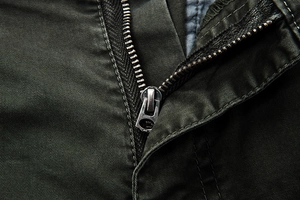 Close-up of durable metal zipper and high-quality olive camo cargo pants fabric