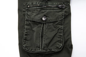 Army green cargo pants featuring utility pockets with metal zippers and button flaps