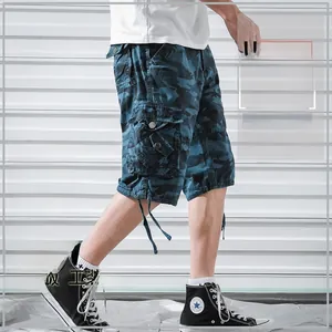 Detail of blue camouflage cargo shorts featuring large side pockets and drawstring hem