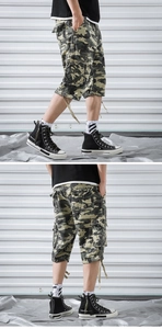 Detail view of camouflage cargo shorts featuring multi-pocket design and drawstring cuffs