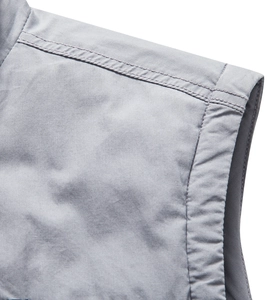 Detailed macro view of gray multi-pocket vest shoulder showing precision double-needle stitching