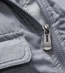 Detail of metal zipper and cargo pocket on a gray outdoor multi-pocket vest jacket