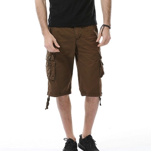 Dettaglio macro dei pantaloncini cargo uomo marrone scuro con tessuto di cotone e grandi tasche