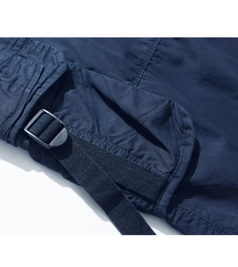 Detail of cargo pocket with black buckle and nylon webbing on navy blue shorts