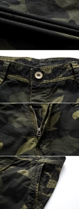 Detailed macro view of camo cargo shorts fabric, metal button, and zipper craftsmanship