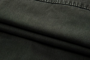 Macro shot of dark grey cotton twill fabric texture and durable double-needle stitching