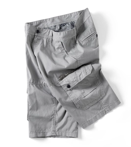 Detail view of grey cargo shorts featuring multi-pocket design and tropical leaf print lining