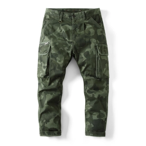 Detail of army green camouflage cargo pants with utility pockets and metal zipper accents