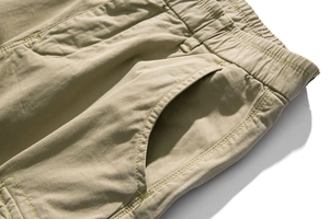 Close-up of elastic waistband and side pocket detail on khaki men cargo trousers