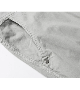 Macro shot of reinforced pocket seam and metal rivet on men's gray cargo shorts
