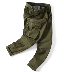 Detailed macro view of army green cargo pants featuring side flap pockets and twill texture