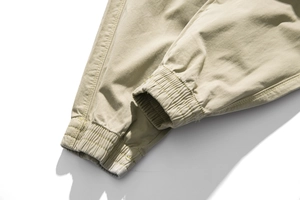 Detailed close-up of khaki cargo pants featuring elastic cuffs and reinforced stitching