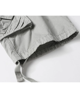 Detail view of light grey cargo shorts fabric with twill texture and drawstring hem
