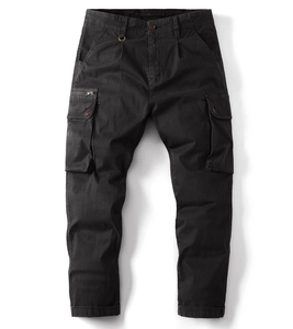 Detail view of dark cargo pants featuring large button flap pockets and metal zipper detail