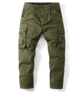 Detail view of olive green cargo pants showing functional flap pockets and metal zipper