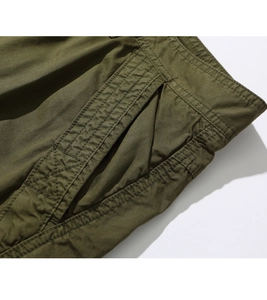 Close-up of olive cargo shorts featuring reinforced side pockets and twill fabric