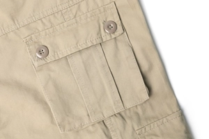 Detail of khaki cargo pants pocket with twill fabric and brown plastic buttons