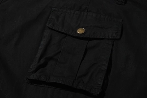 Detail of cargo pocket with bronze snap button and cotton twill fabric on black shorts