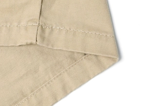 Detailed macro view of khaki cargo pants edge with high-quality double-needle stitching
