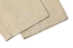 Detail of reinforced double-needle stitching on khaki cargo pants leg cuffs