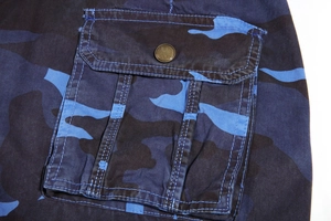 Close-up of camouflage cargo shorts showing tactical pocket with vintage metal button