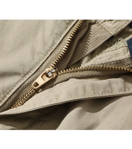 Close-up of durable antique bronze metal zipper on khaki cotton cargo shorts