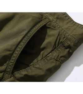 Detail view of reinforced double-stitched pockets on green cargo shorts