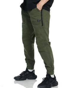 Detail of army green cargo pants showing side zipper pocket and fashion patch on the leg