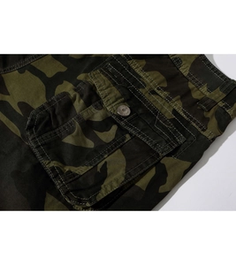 Gros plan d'un short cargo camouflage avec poche latérale et bouton en métal robuste