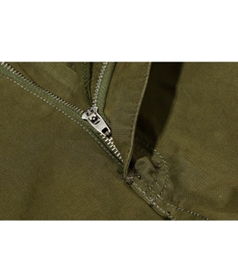 Macro shot of durable metal zipper and olive green twill fabric on cargo shorts