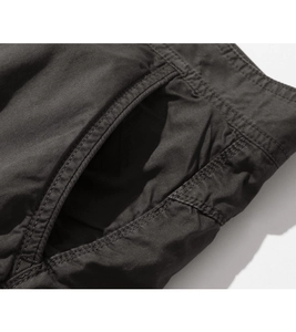 Detail view of cargo shorts showing side pockets and double stitching on cotton fabric