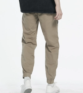 Detail view of khaki jogger pants with elastic cuffs and knee seam stitching details