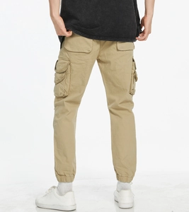Detail of khaki jogger cargo pants featuring elastic cuffs and functional 3D side pockets