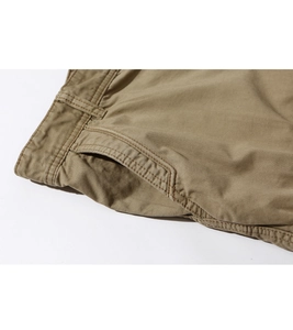 Detail of khaki cargo shorts showing reinforced stitching and cotton twill fabric texture