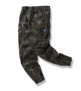 Detail of woodland camo cargo pants featuring elastic drawstring waist and side patch pockets