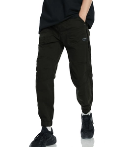 Detail of dark green cargo pants featuring side flap pockets and reinforced knee stitching