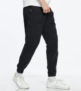 Detail of men's black cargo joggers with large side pockets and elastic cuffs