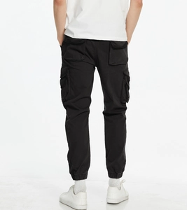 Rear view of black multi-pocket cargo pants with elastic cuffs and durable cotton fabric
