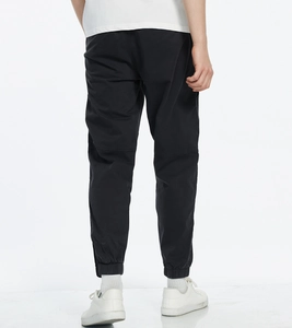 Detail view of black cargo joggers showing knee stitching and elastic cuffs on a male model