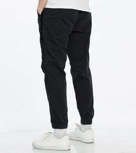 Close-up detail of black men's cargo joggers with elastic cuffs and knee stitching accents