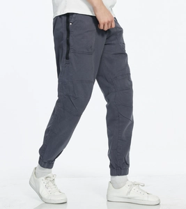 Detail view of dark grey cargo pants with side zipper pockets and ribbed cuffed ankles