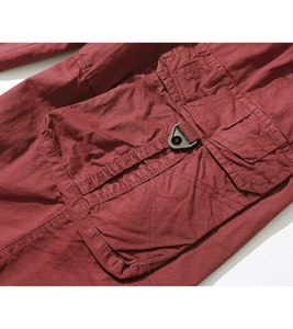 Detail of cargo pants large pocket with D-ring buckle and reinforced stitching