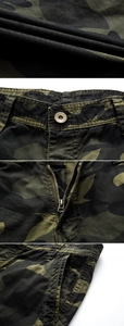 Detailed macro view of camo shorts fabric texture, reinforced seams, and metal zipper closure