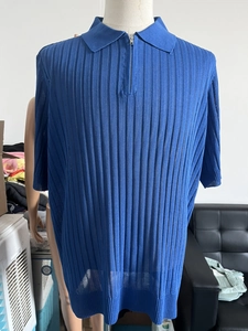 Detail of royal blue knit polo shirt featuring vertical texture and metal half-zip neckline