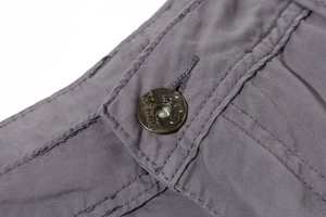 Makroansicht von Cargo-Shorts aus Baumwolle mit Metallknopf und doppelten Steppnähten