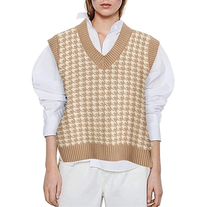 Detail of khaki houndstooth knit vest with V-neckline over a white shirt