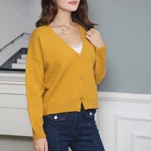 Detailed knit texture of ginger V-neck cardigan with ribbed cuffs and three-button closure