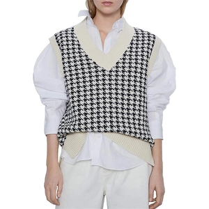 Detail view of the V-neck houndstooth knit vest paired with a white long-sleeve shirt
